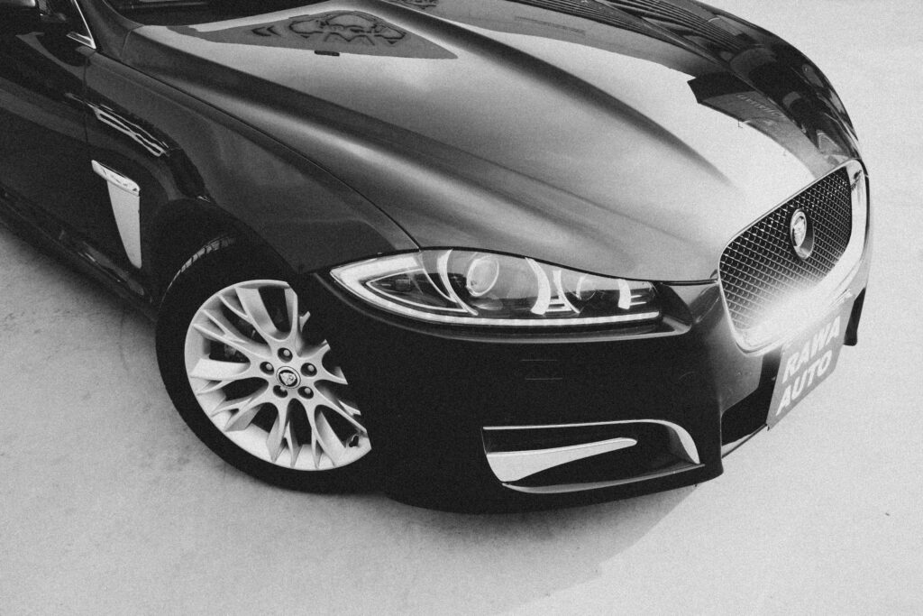 Black and white image of a luxury Jaguar car highlighting its sleek design and elegant curves.